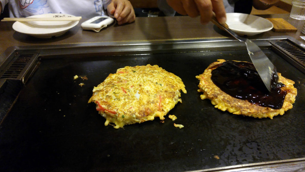 Covering Okonomiyaki with Eel Sauce at Dohtonbori Restaurant
